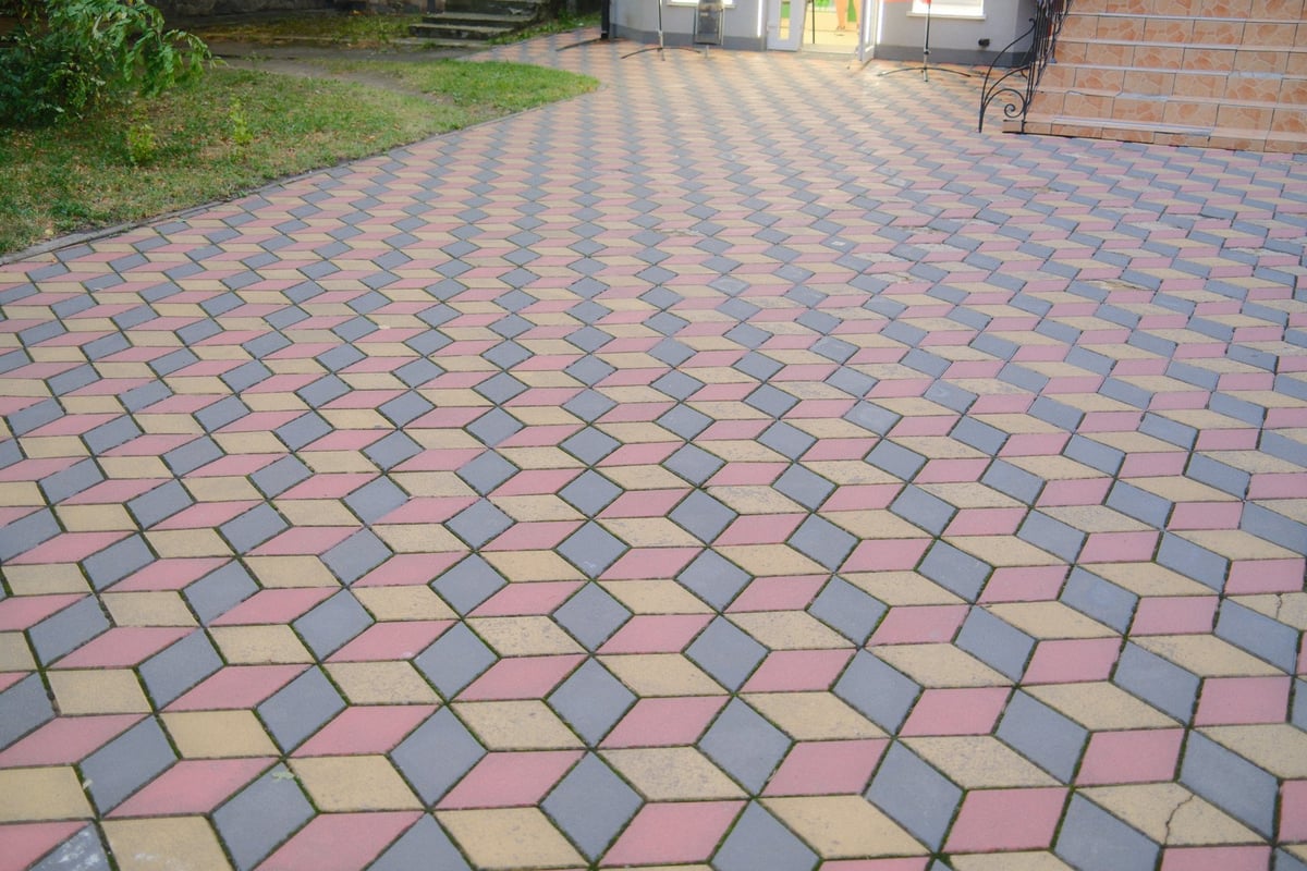 Cleaned patterned driveway leading to a property