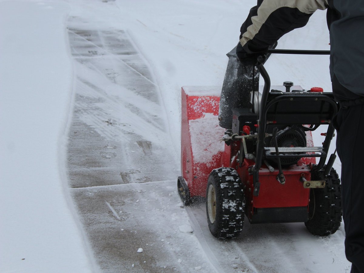 Snow blower clearing a driveway to a clear, safe surface